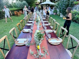 a long wooden table with plates and glasses on it at Luxurious Umbrian Retreat for 10 with Private Terrace and Pool in Torrecola +245 photos