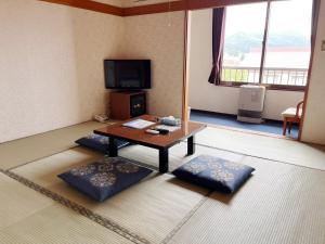 a living room with a coffee table and a tv at Yuzawa Hotel New Fukudaya-ski in ski out in Minami Uonuma