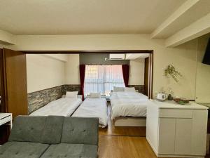 a bedroom with two beds and a mirror at Laforet Tokaichi in Hiroshima