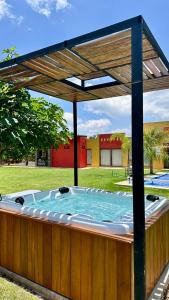 a hot tub under a wooden pergola in a yard at Hotel Quinta los Duraznos in Villa Doctor Mora