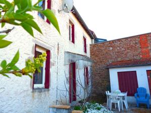 a building with a table and chairs on a patio at Charmante maison familiale avec cour fermée, proche randonnées et sites naturels - FR-1-489-277 in Arfeuilles