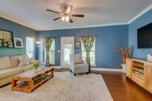 a living room with blue walls and a ceiling fan at Cheerful Nashville Home In Hip Westmeade! in Nashville