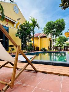 a chair sitting next to a swimming pool at Laa House in Hoi An