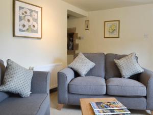a living room with two couches and a table at Jasmine Cottage - Uk4176 in Mayfield