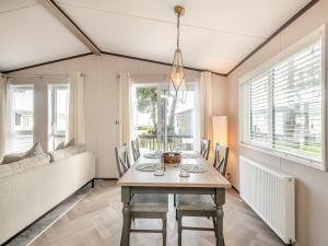 een eetkamer met een tafel en een bank bij Tranquil Dawn in Corton