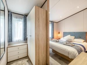 een slaapkamer met een groot bed en een spiegel bij Tranquil Dawn in Corton