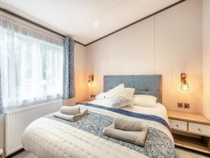 een slaapkamer met een groot bed met twee kussens bij Tranquil Dawn in Corton +6 foto's