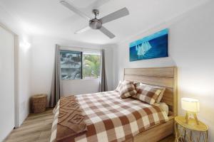 una camera da letto con un letto e un ventilatore a soffitto di 6 Pelican Beach Resort a Noosaville Altre 10 foto