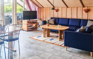 a living room with a blue couch and a table at Nice Home In Hemmet With Sauna in Hemmet