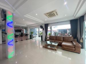 a living room with a couch and a glass table at W-9 Hotel in Nong Prue