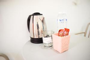 a coffee maker and a glass on a table at Fandee suites in Ban Sa Kut