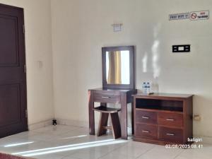 a bathroom with a vanity and a mirror and a stool at Ayuri Guesthouse in Karangasem
