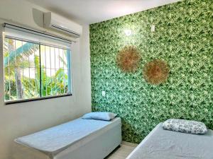 una camera da letto con due letti e una parete verde di Casa Branca A melhor vista da região no Centro de Maragogi a Maragogi Altre 21 foto