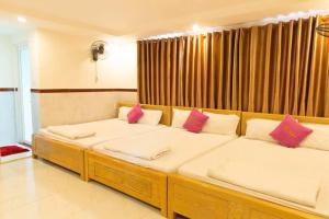 Habitación con 2 camas y almohadas rosas. en Thị Thành Hotel, en Vung Tau