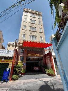 Un edificio alto con un estacionamiento enfrente. en Thị Thành Hotel, en Vung Tau