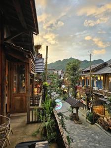 un'area esterna di un villaggio con edifici e tavoli di Góc Homestay & Cocktail bar in Moc Chau Night Market a Mộc Châu
