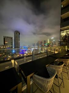 ロサンゼルスにあるBeautiful 1BR - DTLA!!の市街のスカイラインを望む屋上バー(テーブル、椅子付)