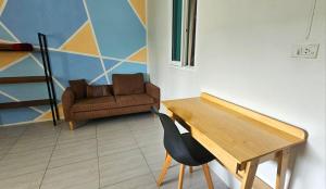 a living room with a table and a chair at Deli Devi Budget Home in Hinkong