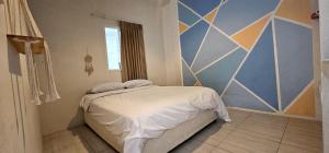 a bedroom with a bed and a geometric wall at Deli Devi Budget Home in Hinkong