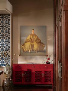 ホーチミン・シティにあるThe Odys Boutique Hotelの壁画のある部屋の赤いキャビネット