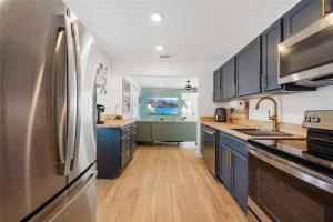 Una cocina con gabinetes azules y un refrigerador de acero inoxidable. en Coastal Comfort 2BR Getaway St Pete, en San Petersburgo 6 fotos más