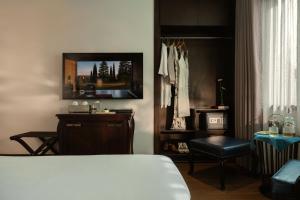 a bedroom with a bed and a table and a chair at The Odys Boutique Hotel in Ho Chi Minh City