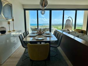 カンクンにある3BR Luxury Oceanfront Apt w/ Pool, Gym & Views!の眺めの良いキッチン(ダイニングテーブル、椅子付)