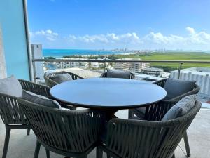 カンクンにある3BR Luxury Oceanfront Apt w/ Pool, Gym & Views!の海が見えるバルコニーにテーブルと椅子がある +49枚の写真
