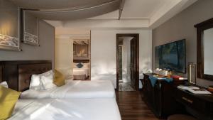 ホーチミン・シティにあるThe Odys Boutique Hotelのベッド2台と机があるホテルの部屋 +100枚の写真