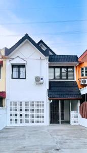 a white house with a black roof at Homestay Rumah Kolek, Shah Alam in Shah Alam