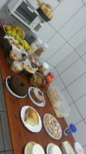 a table topped with lots of different types of food at Pousada Tilu in Aparecida