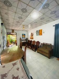 a living room with chairs and a large table at Art house hiriketiya in Dickwella