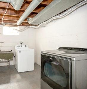 a kitchen with a washing machine and a stove at South Euclid 4BR Luxe Escape with Hot Tub and BBQ in South Euclid
