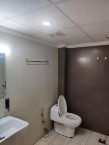 ein Badezimmer mit Toilette und Waschbecken in der Unterkunft EMPIRE THE GRANDE SUITEs in Ernakulam