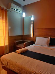 a bedroom with a bed and a chair and a mirror at EMPIRE THE GRANDE SUITEs in Cochin +7 photos