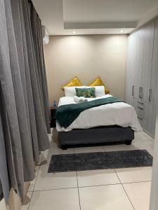 a bedroom with a large bed with curtains and a rug at Cozy Central BNB Mbabane in Mbabane