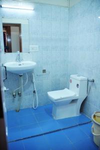 a bathroom with a white toilet and a sink at Abu Residency in Kodaikānāl