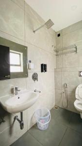 ein Badezimmer mit Waschbecken, Spiegel und Toilette in der Unterkunft Park Abode Boutique Guest House in Guwahati