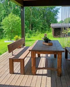 a picnic table and bench on a wooden deck at Brīvdienu māja Dinary in Dagda