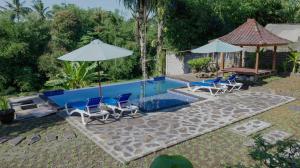 SegantengにあるPerwira Bungalows 1 bedroomのプール(椅子、パラソル、テーブル付)