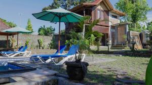 SegantengにあるPerwira Bungalows 1 bedroomのパティオ(椅子、パラソル、プール付)
