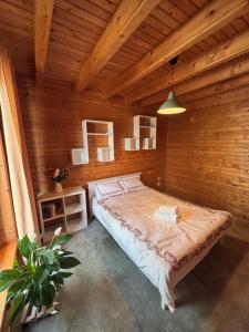 a bedroom with a large bed in a wooden room at Forest & Lake House in Dumbrăviţa