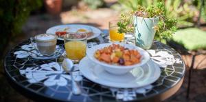 a table with a bowl of food and glasses of orange juice at 84 on Fourth Guest House in Johannesburg