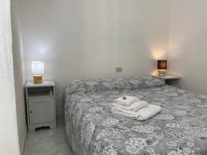 奥尔比亚Passa Parola的卧室里有一张床，床上铺着一条白毛巾