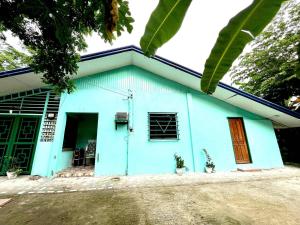 a blue house with a porch and a door at Cebu - Victoria's Guest House in Badian