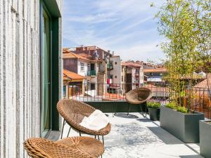 a balcony with chairs and a view of a city at Armazém Luxury Housing- Architectural & Design Hotel in Porto