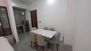 a dining room with a white table and chairs at Imperio Residence Malacca By Al Abraar in Melaka