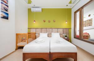 ヘルソニソスにあるMore Crete Village House in Koutouloufari - 6 guests - Poolのベッドルーム(ベッド1台、ベビーベッド1台付) +38枚の写真