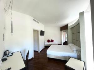 une chambre d'hôtel avec un lit, une table et un bureau dans l'établissement Best Western Cesena Hotel, à Cesena
