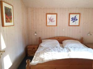a bedroom with a bed and three pictures on the wall at Ferienhaus mit Sauna im Ferienpark Mirow in Granzow